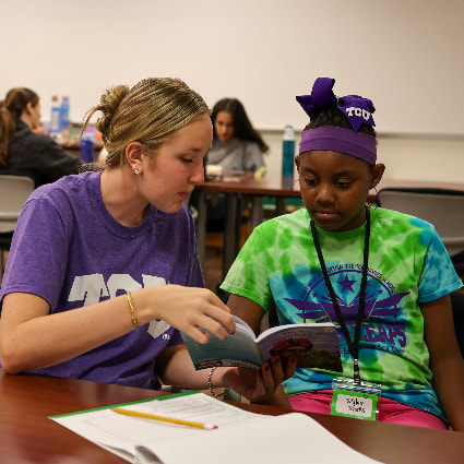 TCU student reading to school-aged child