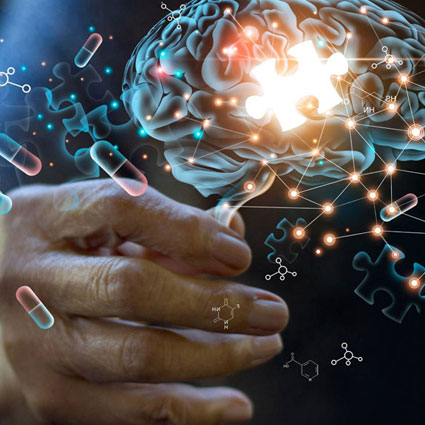 Hand holding illustration of brain with puzzle and pills