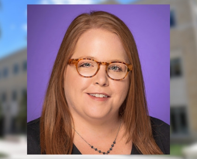 Beth Rogers, smiling, wearing a black shirt, with a black necklace, wearing tortoise shell glasses with a TCU purple background. In the background of the image is a frame of the Annie Richardson Bass Building, blurred.