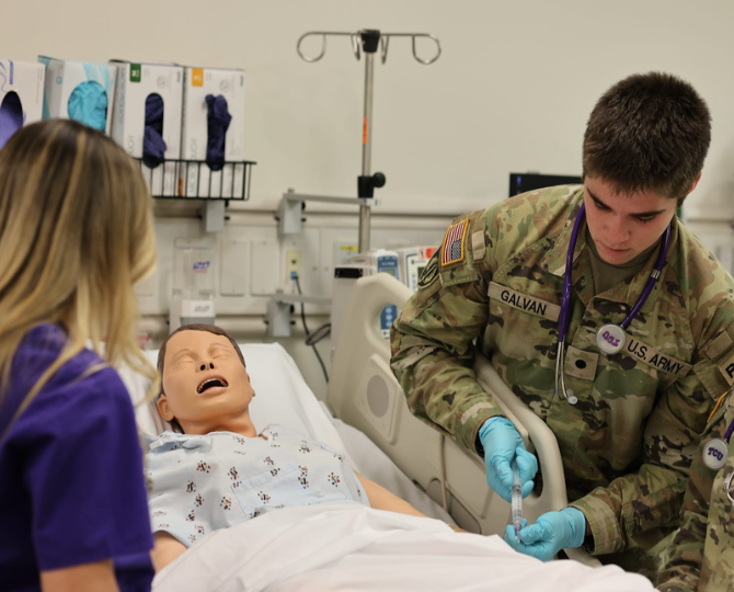 Nicholas Galvan, right, senior undergraduate nursing student and ROTC cadet in a simulation