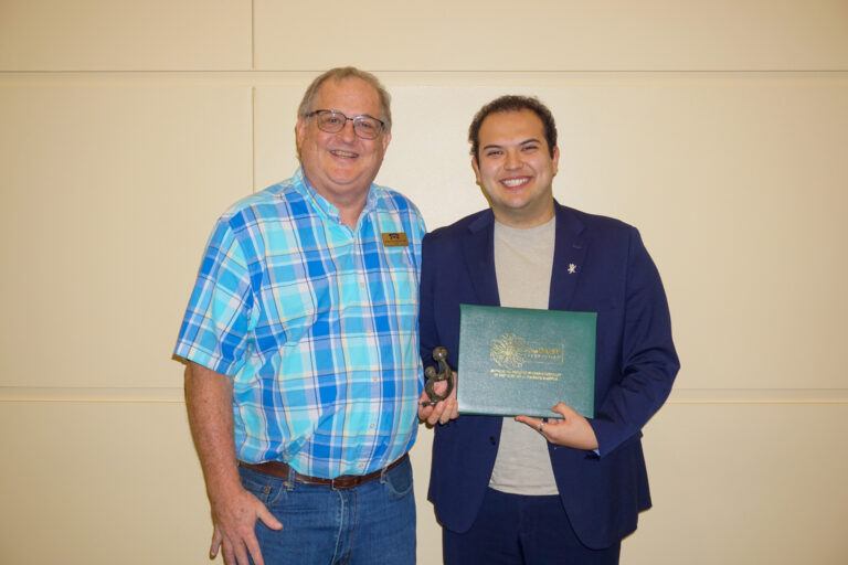 Abell-Hanger Professor of Gerontological Nursing Dr. Dennis Cheek presents the DAISY in Training Award™ to TCU Nursing senior Geo Martinez